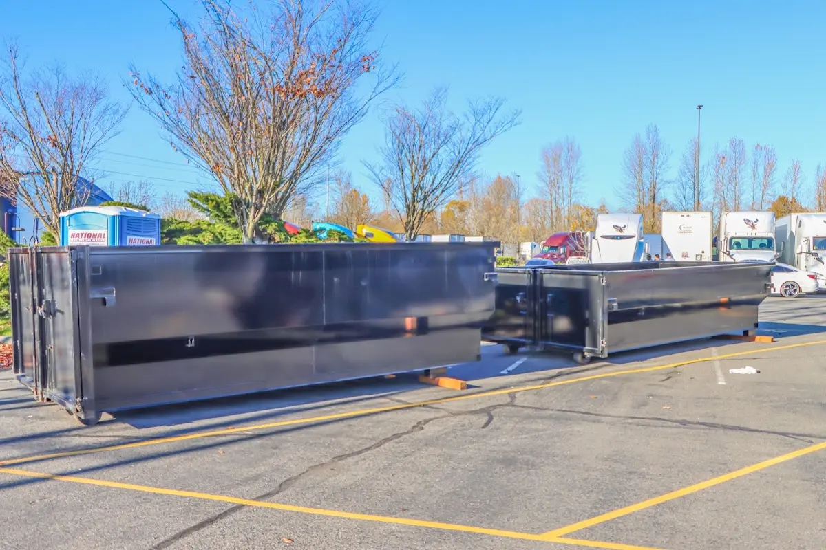 Professional dumpster rental service with roll-off container on residential driveway in St. John